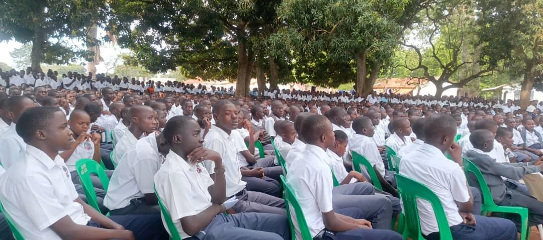 Students gathered under trees for a school outreach